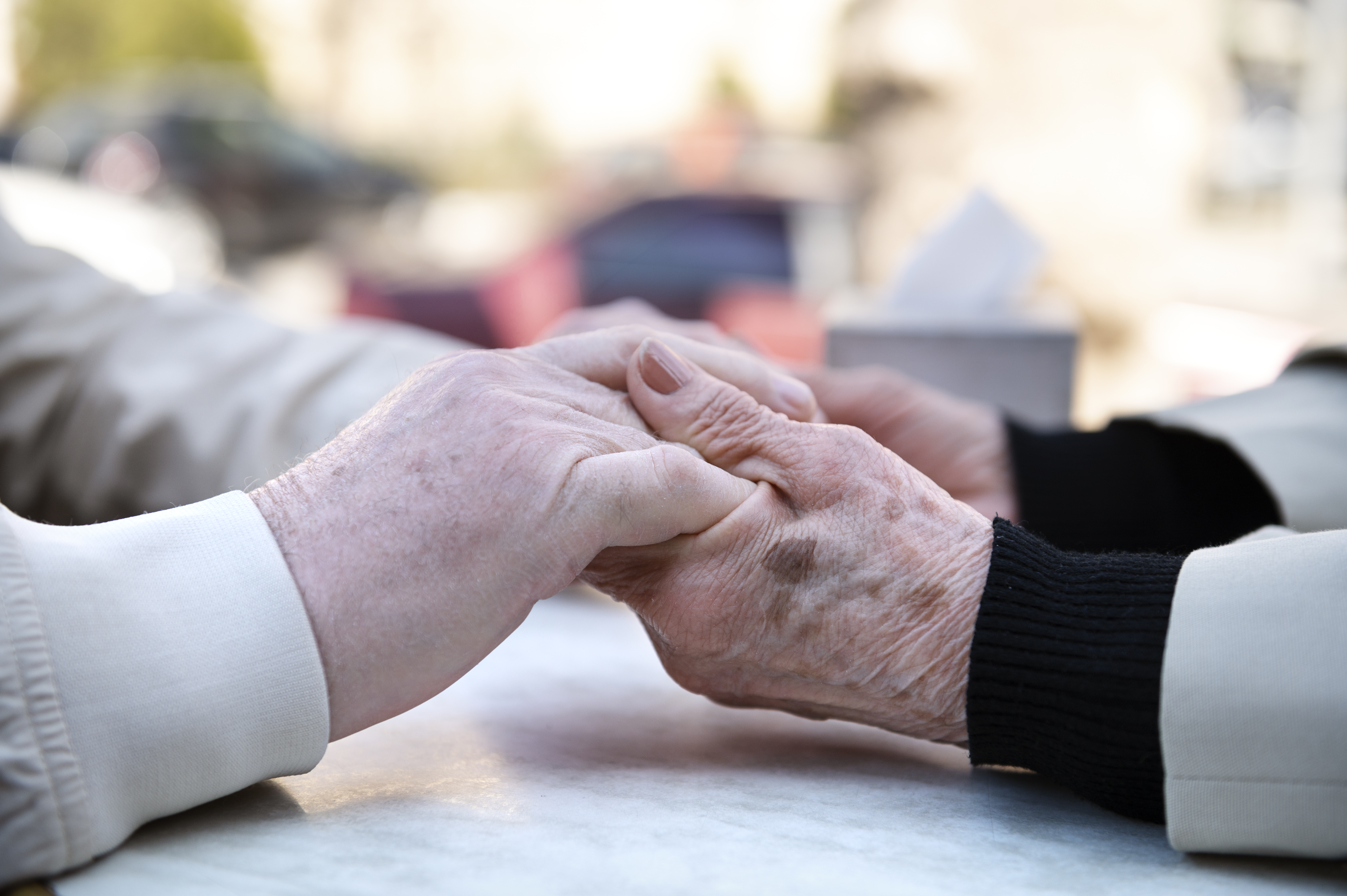 side-view-old-people-holding-hands copia