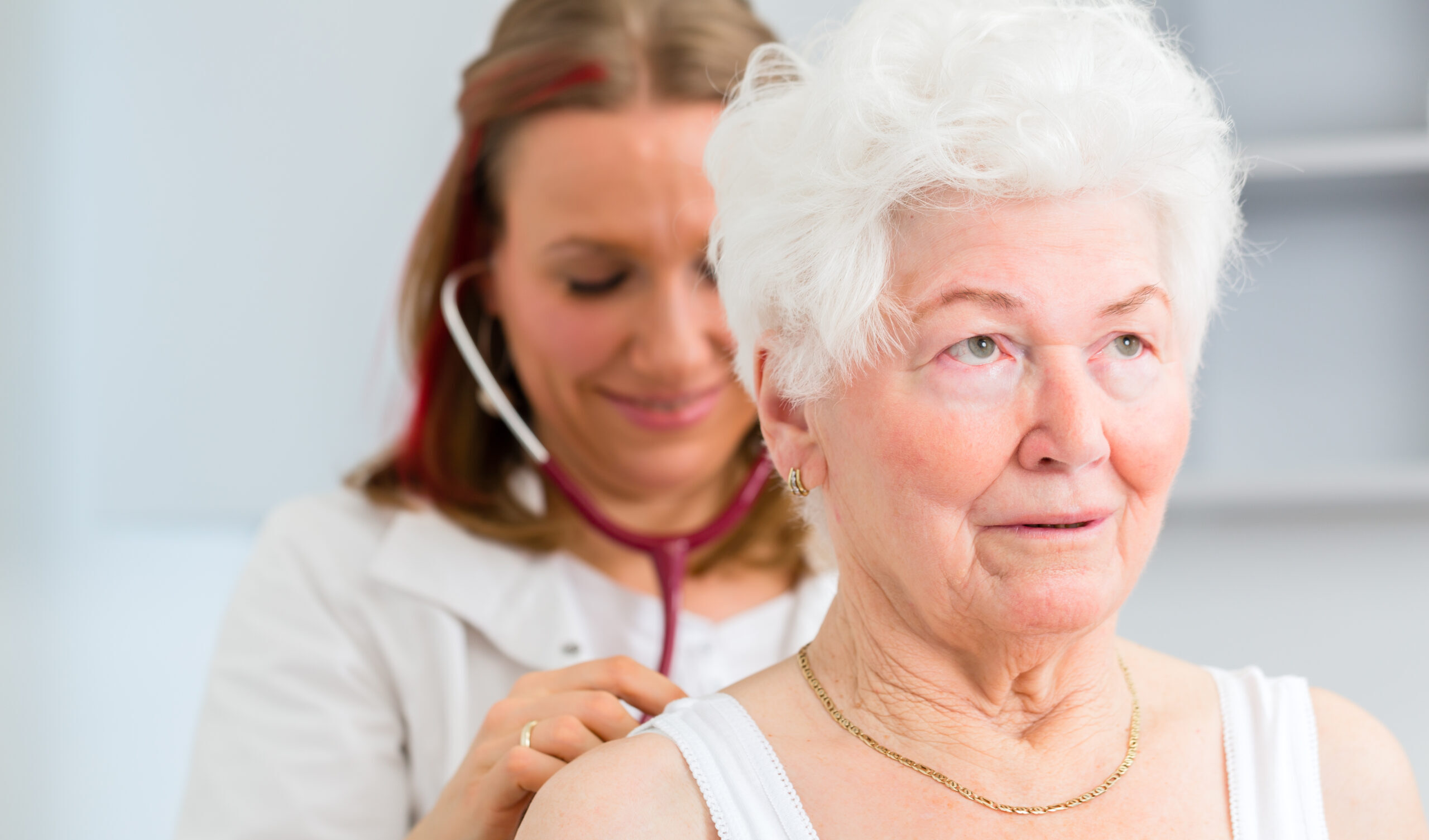 Doctor auscultating senior patient in practice